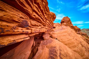 Nevada, Boulder City 'deki Redstone Kumullarını keşfedin. Açık mavi gökyüzünün altındaki canlı kırmızı kaya oluşumlarına ve karmaşık jeolojik dokulara hayret edin. Doğal güzellik için mükemmel.