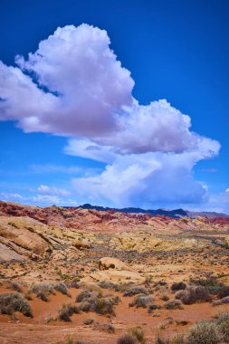 Nevada Moapa Vadisi 'ndeki Ateş Vadisi' nin dingin güzelliğini deneyimleyin. Canlı kırmızı kaya oluşumları, uçsuz bucaksız mavi gökyüzü karşısında nefes kesici bir çöl manzarası yaratıyor..