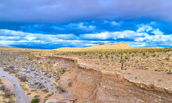 Las Vegas yakınlarındaki Red Rock Kanyonu 'nda yakalanan bu panoramik hava manzarası dramatik fırtına bulutları altında engebeli bir çöl manzarasını sergiliyor..