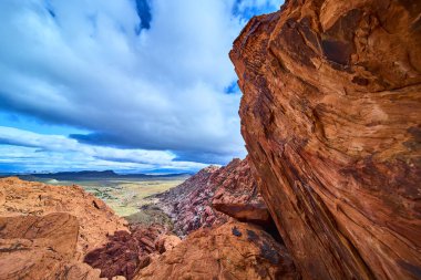 Kızıl Kaya Kanyonlarının Nevada 'daki kızıl kumtaşı kayalıklarına çarpması nefes kesici bir manzara. Uçsuz bucaksız çöl ovalarını keşfedin ve Las Vegas yakınlarında dramatik bir gökyüzü altında zamansız güzellikleri keşfedin..