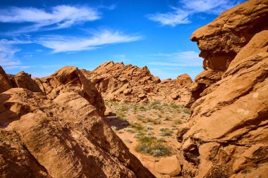 Boulder City Nevada 'daki nefes kesici Redstone Kumullarını keşfedin. Parlak mavi gökyüzüne karşı kırmızı kumtaşı oluşumlarının canlı kontrastını deneyimlemek, macera ve yalnızlık hissi uyandırır..