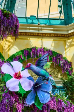 Las Vegas Bellagio Gardens 'ta canlı bir çiçek sergisi ve parıldayan sinekkuşu heykeli. Artan salkım salkımı ve cam konservatuar doğayı uyumu ve güzelliği çağrıştırıyor. Doğa temalı için mükemmel.