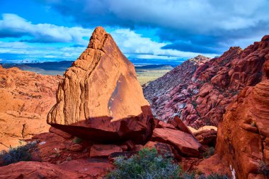 Las Vegas yakınlarındaki Kızıl Kaya Kanyonları 'nın nefes kesici görüntüsü. Dramatik gökyüzü engebeli çöl manzarasını güçlendirir. Şehir hayatının yanında güzellikler sergiler..