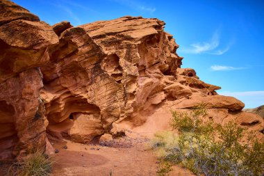 Boulder City Nevada 'da nefes kesici çöl manzarası. Redstone Dune 'da çarpıcı kumtaşı oluşumları canlı mavi gökyüzü ile tezat oluşturuyor. Seyahat ve jeoloji temalı projeler için mükemmel.
