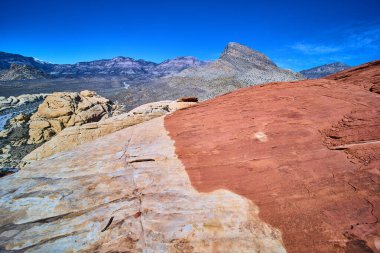 Nevada Red Rock Kanyonu 'nun canlı kırmızı ve kumtaşı güzelliğini tecrübe edin. Engebeli dağlara ve uçsuz bucaksız Amerika 'nın güneybatısını tanımlayan açık mavi gökyüzüne hayret. Seyahat için mükemmel.