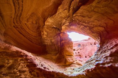 Nevada, Boulder City 'deki Redstone Dune' un canlı kumtaşı tavanına bakın. Güneş ışığı, Amerikan Güneybatı Çölü 'nde dramatik bir doğal sanatsal gösteri sergileyerek dönen desenleri vurguluyor.