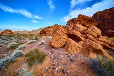 Nevada, Boulder City 'deki parlak mavi gökyüzüne karşı görkemli kızıl kaya oluşumları yükseliyor. Ateş Vadisi Parkı 'nda büyüleyici bir çöl sahnesi. Macera ve keşif temaları için ideal..