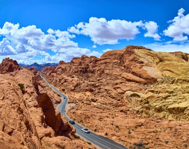 Nevadas Ateş Vadisi 'nin büyüleyici güzelliğini keşfedin. Canlı kırmızı kaya oluşumları ve dolambaçlı bir yol parlak mavi gökyüzü altında maceraya ve keşiflere davetiye çıkarıyor. Seyahat için mükemmel..