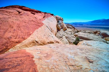 Nevada 'daki görkemli Red Rock Kanyonu açık mavi gökyüzünün altında canlı kumtaşı kayalıkları sergiliyor. Las Vegas yakınlarındaki bu çarpıcı çöl manzarasının sükunetini ve enginliğini hissedin..