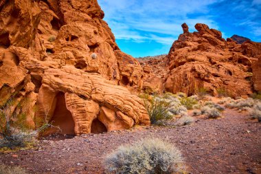 Boulder City Nevada 'daki nefes kesici Redstone Dune' u keşfedin. Huzurlu mavi gökyüzüne karşı canlı kırmızı kaya oluşumlarına hayret edin. Seyahat ve macera temalı projeler için mükemmel.
