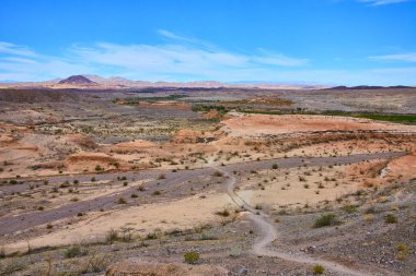 Nevada, Boulder City 'deki Baykuş Kanyonu' nun uçsuz bucaksız çöl güzelliğini keşfedin. Parlak mavi bir gökyüzünün altında, engebeli arazi ve uzak dağlar kurak çölde macera ve sükuneti davet ediyor..