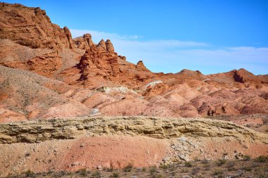 Nevadas Northshore Yolu 'nun engebeli güzelliğini keşfedin, göz kamaştırıcı kırmızı-kahverengi kaya oluşumları açık mavi gökyüzü ile buluşuyor, doğayı gözler önüne seriyor, sanatçılık ve jeolojik tarih nefes kesici bir çöl.