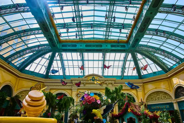 Las Vegas 'taki büyüleyici Bellagio Bahçeleri' ne gelin. Canlı kelebek heykelleri ve çiçek aranjmanları çarpıcı cam tavanlı bir konservatuarın altında serin bir kaçış yaratıyor..