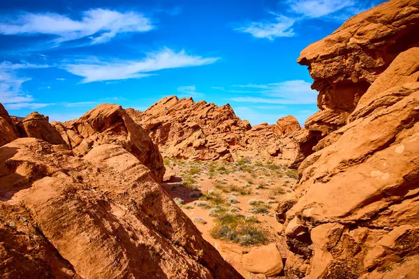 Boulder City Nevada 'daki nefes kesici Redstone Kumullarını keşfedin. Parlak mavi gökyüzüne karşı kırmızı kumtaşı oluşumlarının canlı kontrastını deneyimlemek, macera ve yalnızlık hissi uyandırır..