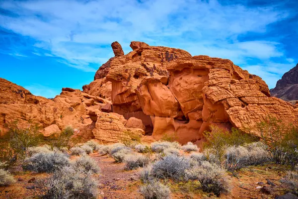 Nevada, Boulder City 'de Redstone Dune' un çarpıcı kızıl kaya oluşumlarını keşfedin. Açık mavi gökyüzünün altındaki bu çöl manzarasının canlı renklerini ve engebeli güzelliğini hissedin..