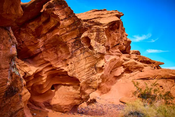 Görkemli kırmızı kumtaşı kayalıkları Boulder City Nevada 'da canlı mavi bir gökyüzüne karşı yükseliyor. Bu nefes kesici çöl manzarası sanatsal özellikleri sergiliyor ve macera arayanları keşfetmeye davet ediyor..