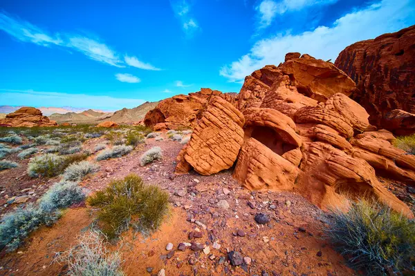 Nevada, Boulder City 'deki parlak mavi gökyüzüne karşı görkemli kızıl kaya oluşumları yükseliyor. Ateş Vadisi Parkı 'nda büyüleyici bir çöl sahnesi. Macera ve keşif temaları için ideal..