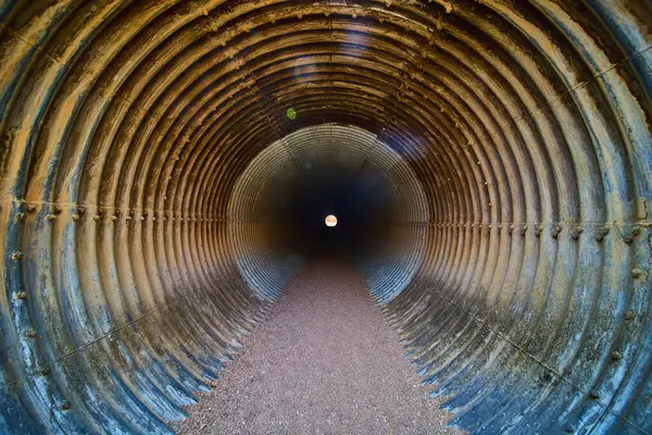 Nevada, Boulder City 'deki Baykuş Kanyonları tünelinin kırsal derinliklerine yolculuk. Bükülmüş metal ve çakıl yolu umut verici bir ışığa doğru yol alıyor, gelişimi ve geçişi somutlaştırıyor..