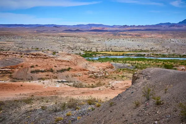Boulder City Nevadas Baykuş Kanyonu: Canlı çöl kayaları ve seyrek yeşillik ile çarpıcı bir çöl manzarası, dolambaçlı bir nehrin kurak araziye hayat ve renk verdiği yer.