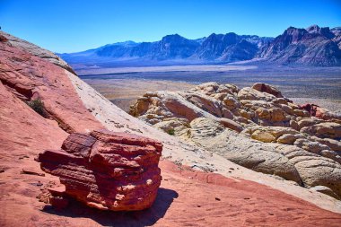 Las Vegas, Nevada yakınlarındaki çarpıcı Red Rock Kanyonu 'nu keşfedin. Canlı kırmızı kumtaşı oluşumları ve görkemli dağlar açık mavi bir gökyüzü altında birleşerek Amerika 'nın güneybatısının özünü yakalıyor..