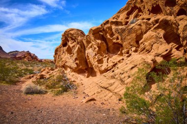 Redstone Dune, Boulder City 'nin engebeli güzelliğini keşfedin. Açık mavi gökyüzü altında çarpıcı kırmızı ve turuncu kaya oluşumları Nevada çöllerinin zamansız cazibesini yansıtıyor..