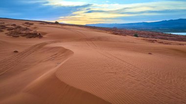 Utah Kasırgası yakınlarındaki Sand Hollow Eyalet Parkı 'ndaki kırmızı kum tepeciklerinin hava görüntüsü engebeli kaya oluşumları ve gün doğumunda sakin göl macera ve açık havada yolculuk için mükemmel.