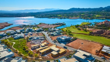 Las Vegas Gölü 'ndeki yemyeşil bir golf sahasının yanında inşa edilmiş lüks göl manzaralı evler. Arka planda emlak ve yaşam tarzı için ideal mavi sular ve manzaralı dağlar var.