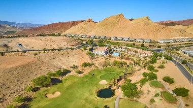 Las Vegas Gölü 'ndeki lüks bir golf sahası topluluğunun havadan görünüşü modern evler yüzme havuzu ve parlak mavi gökyüzünün altında dramatik çöl dağları gayrimenkul ve seyahat temaları için mükemmel.