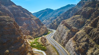 Virgin Nehri Vadisi Arizona 'daki dik kanyon duvarlarından geçen dolambaçlı bir otoyolun havadan görüntüsü. Güneşli kayalar ve uzak dağlar Amerika 'nın güneybatısında macera ve özgürlüğe ilham veriyor..