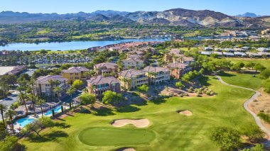 Las Vegas Nevada Gölü 'ndeki golf sahasını çevreleyen lüks villaların ve palmiye kaplı sokakların havadan görünüşü. Arka planda manzaralı çöl dağları olan Las Vegas Gölü' nde yaşam tarzı kavramı.