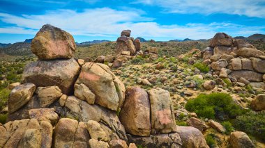 Arizona 'nın kurak çöllerine dağılmış devasa granit kayaların hava manzarası seyrek bitki örtüsü ve açık gökyüzü Amerika' nın güneybatısının saf güzelliğini ve yalnızlığını yakalıyor.