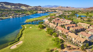 Las Vegas Gölü 'ndeki lüks göl kenarı topluluğunun havadan görünüşü. Parlak güneşli bir günde, verimli bir golf sahası, parlak mavi sular ve lüks konutlarla çevrili.
