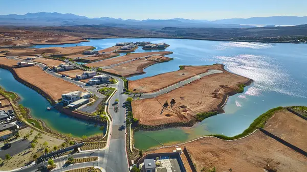 Nevada Çölü 'nde parlak mavi bir göl boyunca inşa edilmiş lüks deniz manzaralı evler. Uzakta dağlar modern yaşam ve emlak gelişimini gözler önüne seriyor.