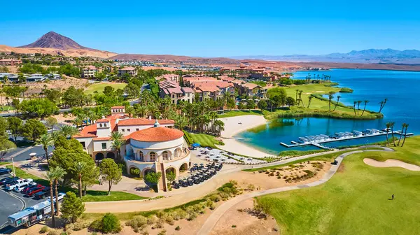 Las Vegas Gölü 'ndeki lüks göl manzaralı bir tatil köyünde Akdeniz tarzı canlı bir golf sahası ve açık mavi gökyüzü altında dağlarla ve palmiye ağaçlarıyla çevrili bir marina.