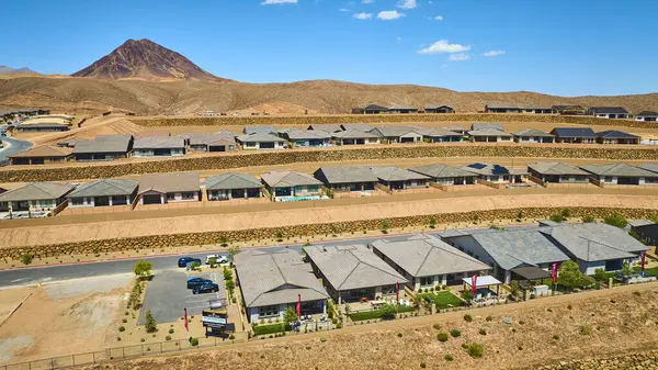 Çağdaş Las Vegas Gölü toplumundaki tek katlı evlerin havadan görünüşü teraslı bahçeleri ve Nevada 'nın parlak gökyüzünün altında dramatik çöl dağlarına kurulmuş taş istinat duvarları.