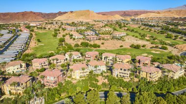 Las Vegas Gölü 'ndeki lüks villaların ve golf sahasının havadan görünüşü. Etrafı çöl dağları ve palmiye ağaçlarıyla çevrili. Amerika Birleşik Devletleri' nin banliyölerinde lüks yaşam ve tatil köylerinde lüks konforlar sergiliyorlar.