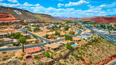 St. George Utah 'ın canlı bir banliyö semtinin havadan görünüşü. Kızıl kaya tepeleri ve çöl manzaralarıyla çevrili. Modern ev halkının yaşadığı ve güneybatı manzarasının çarpıcı olduğu bir yer.