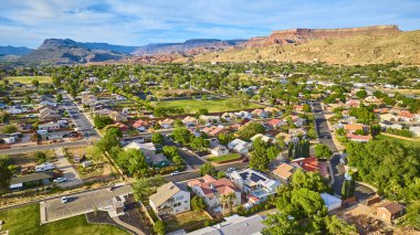Utah Kasırgası 'ndaki canlı bir banliyö mahallesinin havadan görünüşü. Ağaç kaplı caddeler yeşil park ve çarpıcı kızıl kayalar emlak camiası veya güneybatı yaşam temaları için ideal.