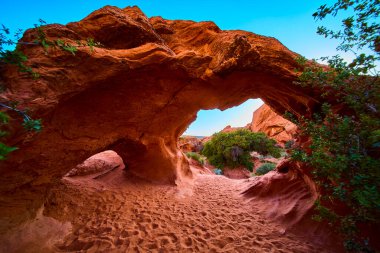 Utah Kasırgası 'ndaki Babil Kemeri' nden gün ışığına çıkan manzara dramatik kırmızı kumtaşı dokularını mavi gökyüzünü ve kumdaki yeşil ayak izlerini gözler önüne seriyor. Bu ikonik Amerikan güneybatı sahnesinde maceraya davetiye çıkarıyor.