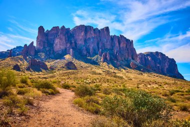 Batıl inançlı engebeli dağlar, Phoenix Arizona yakınlarındaki Kayıp Hollandalı Eyalet Parkı 'nda bir çöl yürüyüş yolunun üzerinde yükseliyor. Macera ve Amerika' nın güneybatısının doğal güzelliğini sergiliyorlar..