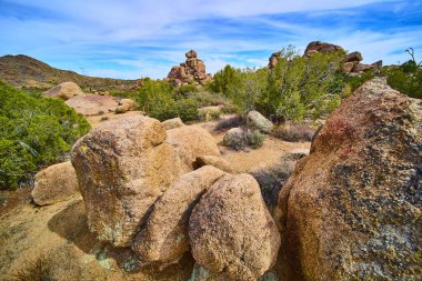Görkemli granit kayalar ve engebeli kaya oluşumları Birleşik Devletler 'in hiçlik yakınlarındaki Arizona çölünden canlı bir gökyüzünün altında yükseliyor. Dayanıklı çalılar bu zamansız vahşi doğaya hayat katıyor..