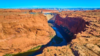 Kuzey Arizona 'nın derin kırmızı kanyonlarını kaplayan Glen Canyon Barajı' nın hava manzarası. Aşağıda Colorado Nehri kıvrılıyor ve açık mavi gökyüzü Amerika 'nın güneybatısının ihtişamını vurguluyor.