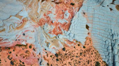 Mermer Kanyon 'un havadan görünüşü Vermilion Kayalıkları' nda dönen kırmızı ve beyaz kumtaşı katmanlarını gösteriyor. Çöl bitkileri Arizona 'nın vahşi doğasının dramatik dokusunu vurguluyor.