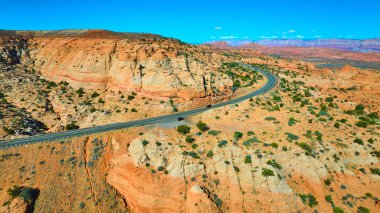 Arizona Mermer Kanyonu ve Parlak mavi gökyüzünün altındaki Vermilion Kayalıkları 'ndan geçen dolambaçlı bir otoyolun havadan görünüşü macera yolculuğunun ruhunu ve Amerika' nın güneybatısının güzelliğini yansıtıyor..
