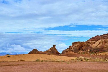 Canlı kırmızı ve turuncu kumtaşı oluşumları Arizona 'daki bir çöl amfi tiyatrosunda belirgin bir şekilde yükseliyor. Büyük gökyüzünün altında, Amerikan Güneybatısının zamansız güzelliğini ve vahşi ruhunu yakalıyor..
