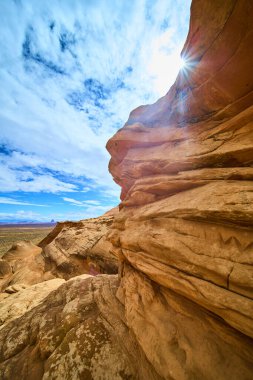 Arizona 'daki bir amfi tiyatronun dramatik kırmızı kumtaşı uçurumlarında güneş ışığı patlıyor. Sayfa yakınlarındaki bir amfi tiyatroda çöl manzaraları ve canlı gökyüzü, Amerikan Güneybatı vahşi doğasının ebedi ruhunu yakalıyor..