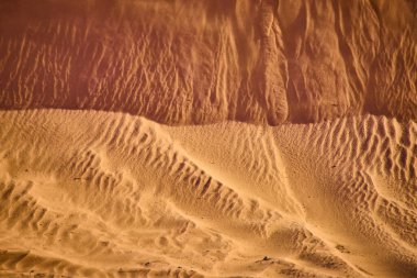 Utah 'taki Sand Hollow Eyalet Parkı' ndaki altın kum tepeciklerinin havadan görünüşü. Karmaşık rüzgar şekilli dokular ve dramatik gölgeler çöl manzarasının ham güzelliğini ve yalnızlığını yakalıyor..