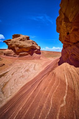 Canlı kırmızı kumtaşı dalgaları ve yontulmuş kaya oluşumları Arizona 'nın yakınlarındaki Arı Kovanı Yolu' nda dramatik bir mavi gökyüzünün altında Amerikan Güneybatı Çölü 'nün saf güzelliğini gözler önüne seriyor..