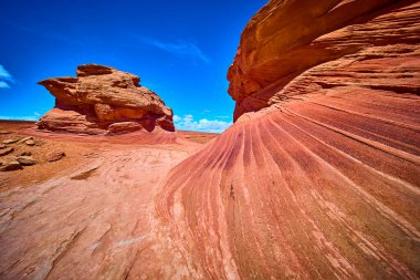 Dramatik kumtaşı oluşumları ve canlı kaya katmanları Arizona çölünde Beehive Trail ve New Wave yakınlarında parlak mavi bir gökyüzü altında parıldıyor..