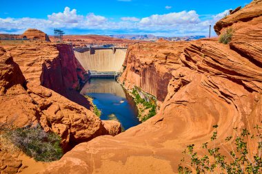 Glen Canyon Barajı Arizona 'daki dramatik kırmızı kaya kanyonlarının arasından yükseliyor. Colorado nehri mavi bir gökyüzünün altında sürükleniyor. Sayfa yakınlarındaki mühendislik ve doğal güzelliğin hayranlık uyandıran karışımını yakalıyor.